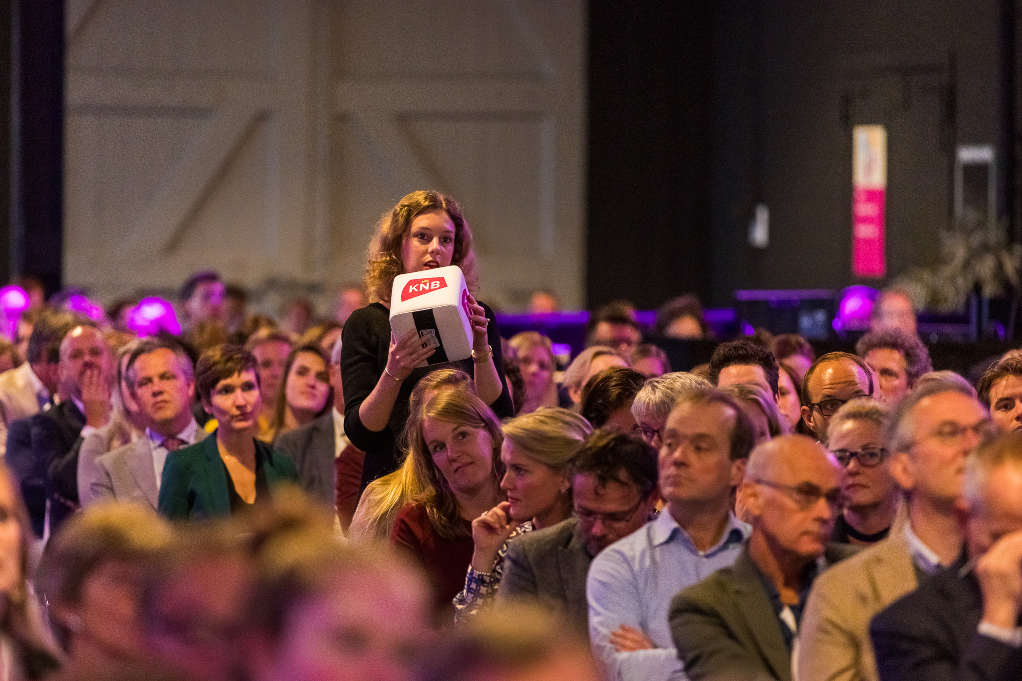 Een vrouw in het publiek praat door een catchbox